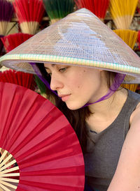 Portrait of woman with vietnamese hat and red fan