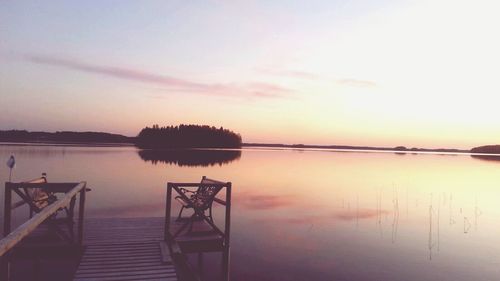 Pier on calm lake at sunset