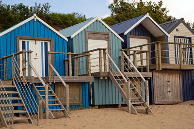 Beach huts on abersoch beach against blue sky