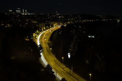 High angle view of illuminated road amidst buildings at night