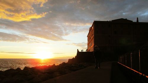 View of sea against cloudy sky at sunset