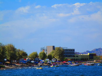 Boats in lake against buildings in city