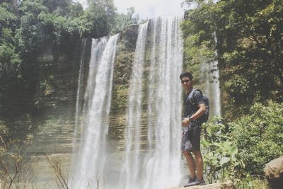 Full length of young man against waterfall