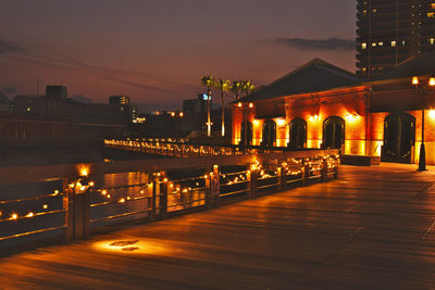 Illuminated buildings against sky at night
