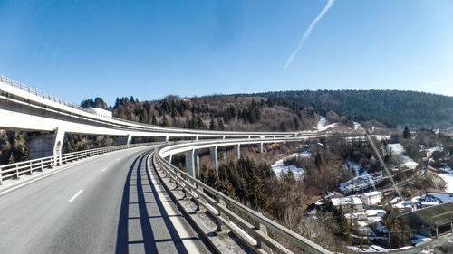 Road by bridge against sky during winter