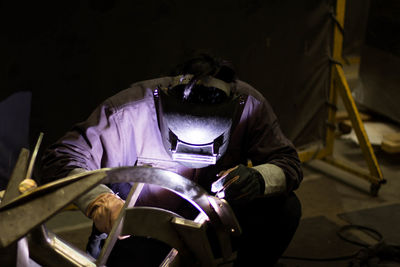 Man welding metal at factory