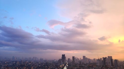 View of buildings against cloudy sky during sunset