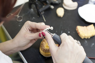 Cropped hands of woman carving small crown