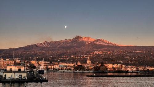 Panoramic view of the eastern side of etna with the full moon approaching sunset