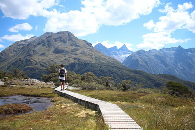 Rear view of man on mountain against sky