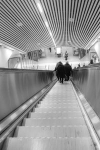 Rear view of people walking on subway station