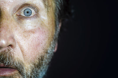 Close-up portrait of man against black background