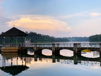 Bridge over river against sky during sunrise