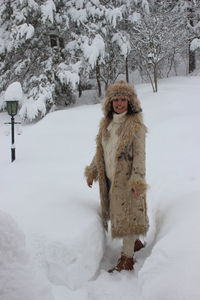 Portrait of woman standing on snow covered field