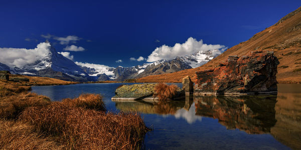 Scenic view of lake and mountains against sky during winter