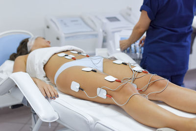 Midsection of women lying in kitchen