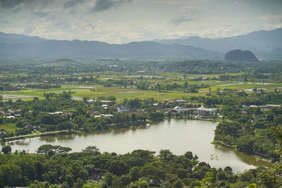 Scenic view of lake by townscape against sky