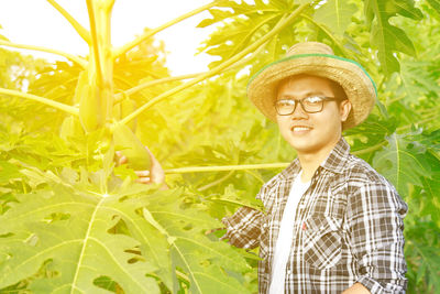 Portrait of young man with papaya plant
