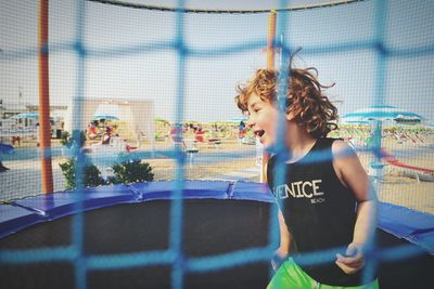 Cute boy playing on trampoline 