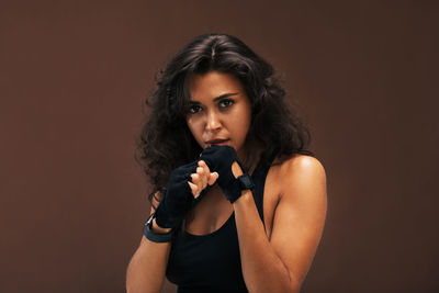 Determined female boxer against brown background