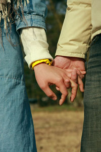 Midsection of couple holding hands outdoors
