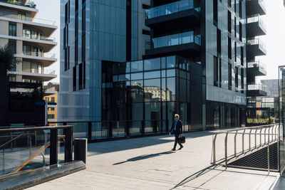 Businessman walking with briefcase outside office building