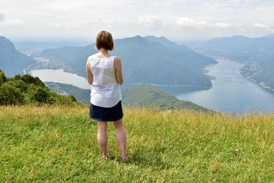 Rear view of woman standing on mountains