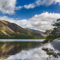 Scenic view of lake by mountains against sky