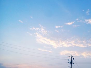 Low angle view of electricity pylon against blue sky