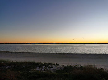 Scenic view of sea against clear sky during sunset