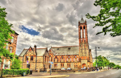 Buildings in city against cloudy sky