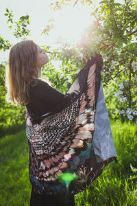 Woman with shawl touching apple blossoms scenic photography