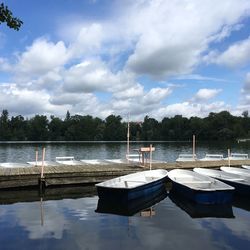 Boats moored in lake against sky