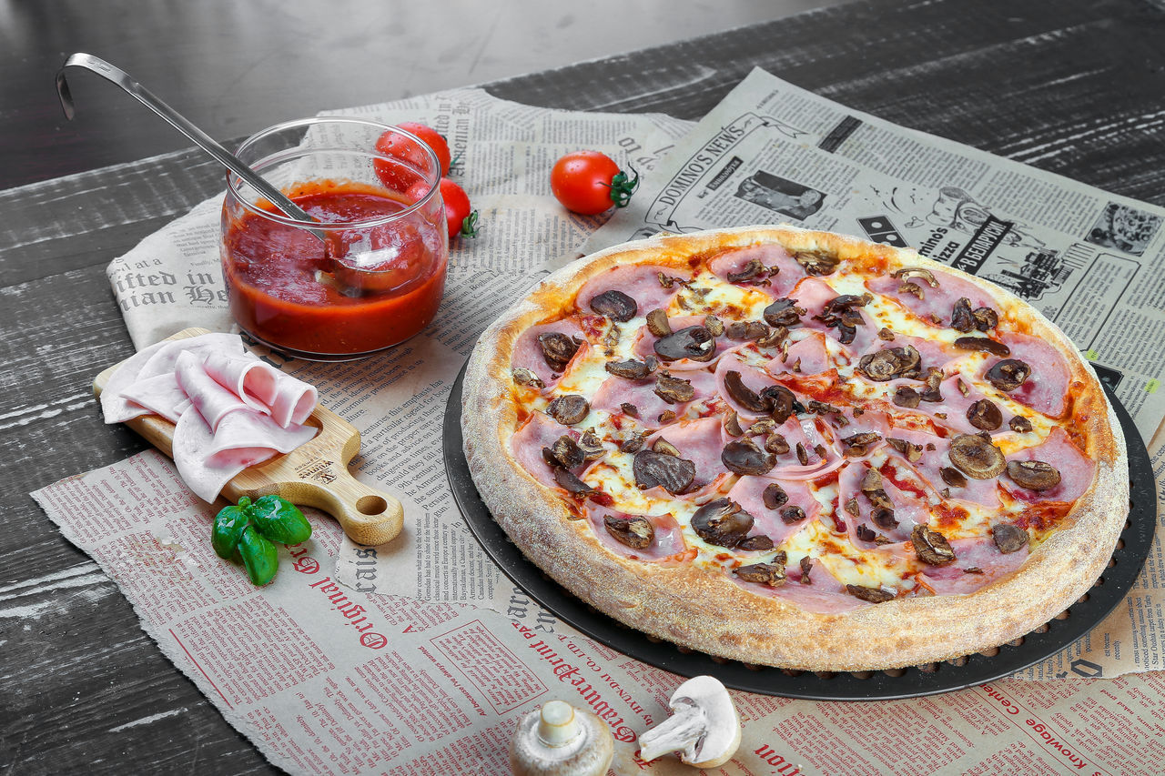 CLOSE-UP OF PIZZA ON TABLE WITH SPOON