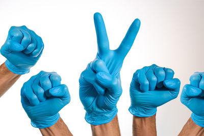 Close-up of hands against blue background