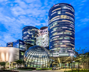 Low angle view of modern building against cloudy sky