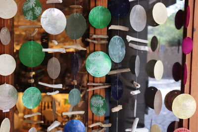 Close-up of multi colored decorations hanging on wood