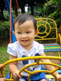Portrait of cute boy sitting in playground