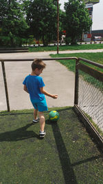 Boy playing with ball on field