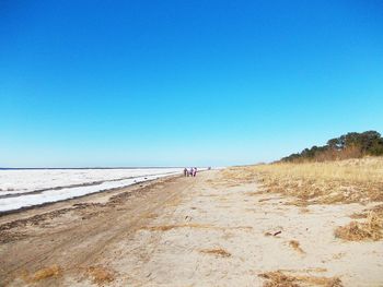 Scenic view of beach against clear blue sky