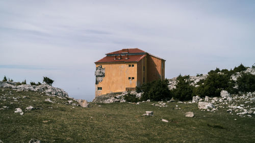 Traditional building on field against sky