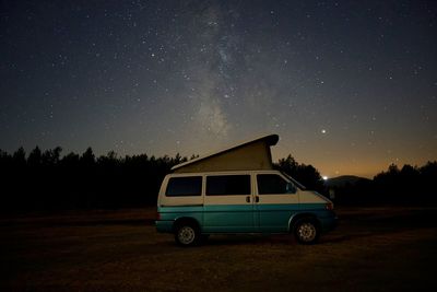 Vintage car on field against sky at night