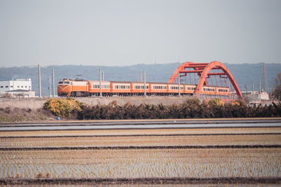 Train on bridge against clear sky