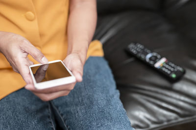 Midsection of man using mobile phone