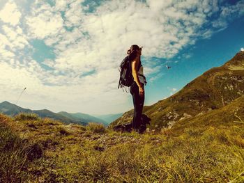 Woman standing on mountain against sky