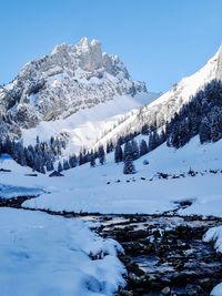 Scenic view of snow covered mountains against sky