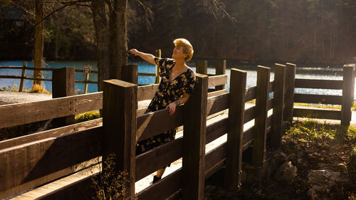 Rear view of woman standing by fence
