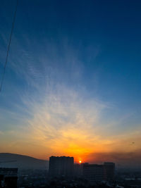 Silhouette buildings against sky during sunset