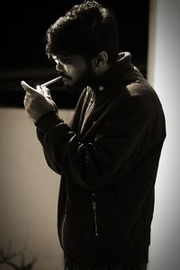 Side view of young man looking at camera