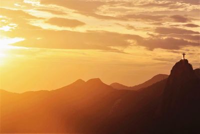 Silhouette of mountain against cloudy sky